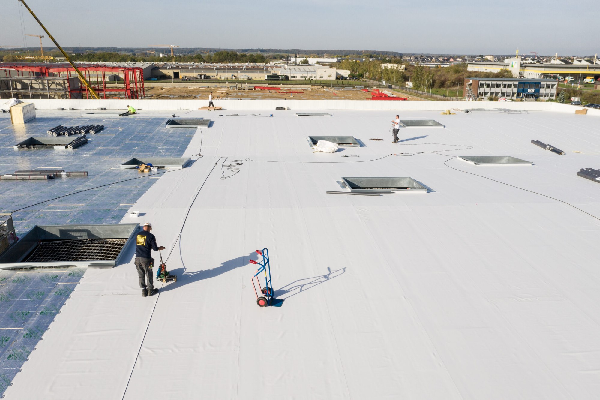Pose d’une membrane d’étanchéité PVC blanche sur une grande toiture-terrasse industrielle